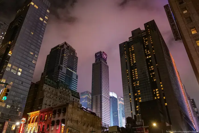 A photo of Manhattan buildings against a pink sky